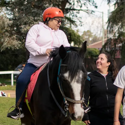 Una paciente adulta monta a caballo acompañada por integrantes del equipo de Alaia